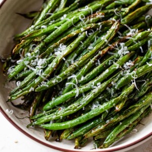 air fryer green beans in a bowl with grated cheese on top