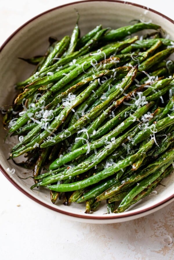 air fryer green beans in a bowl with grated cheese on top
