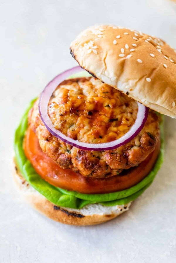 a turkey burger sandwich with a bun, lettuce, tomato, and red onion