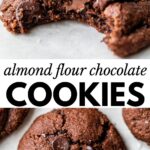 two chocolate cookies on parchment paper, one with a bite taken out of it