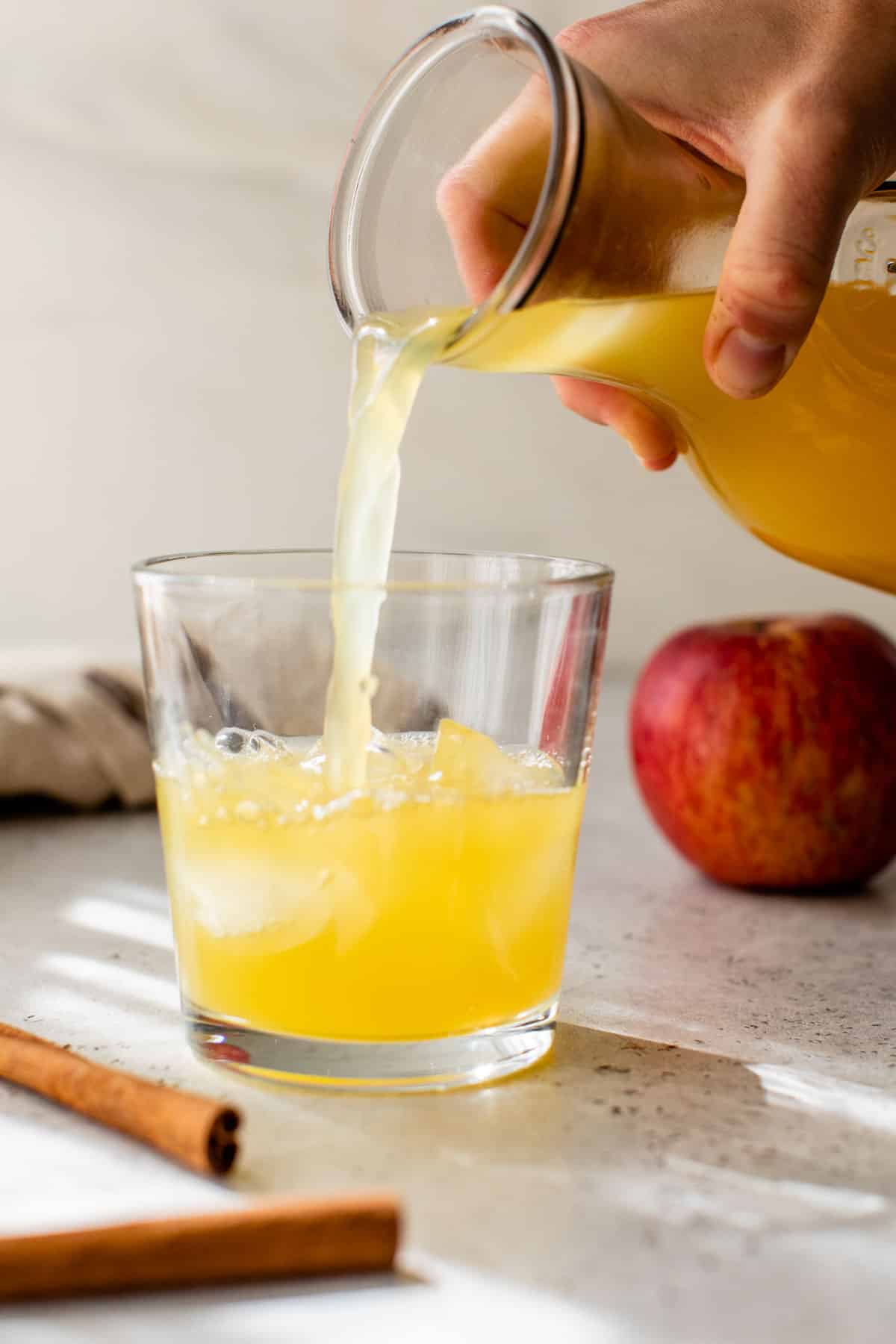 apple cider punch poured into a glass over ice