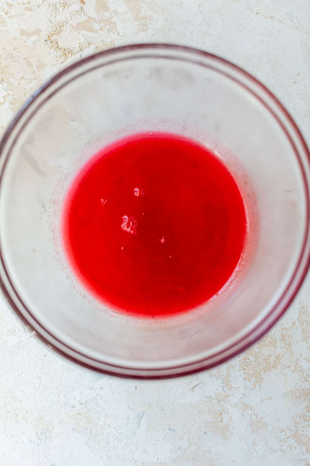 overhead view red cranberry syrup for apple cranberry scones in a glass bowl.