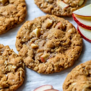 close up on baked apple oatmeal cookies next to thin apple slices.