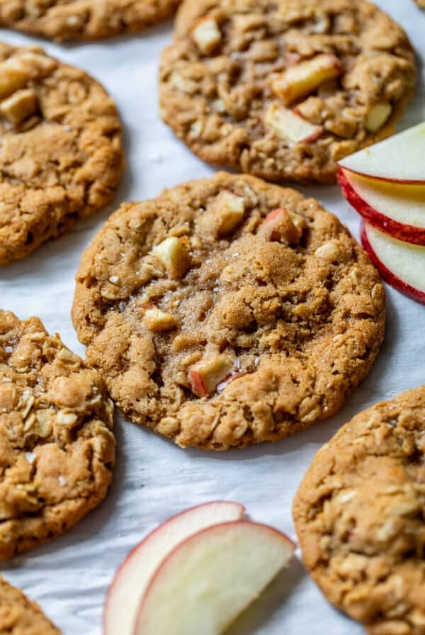 close up on baked apple oatmeal cookies next to thin apple slices.