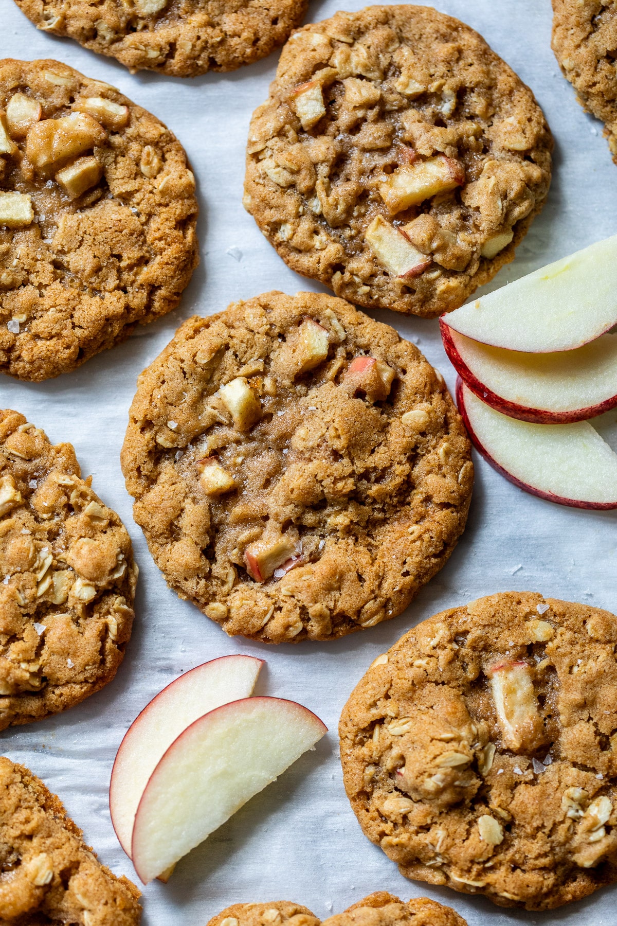 close up on baked apple oatmeal cookies next to thin apple slices.