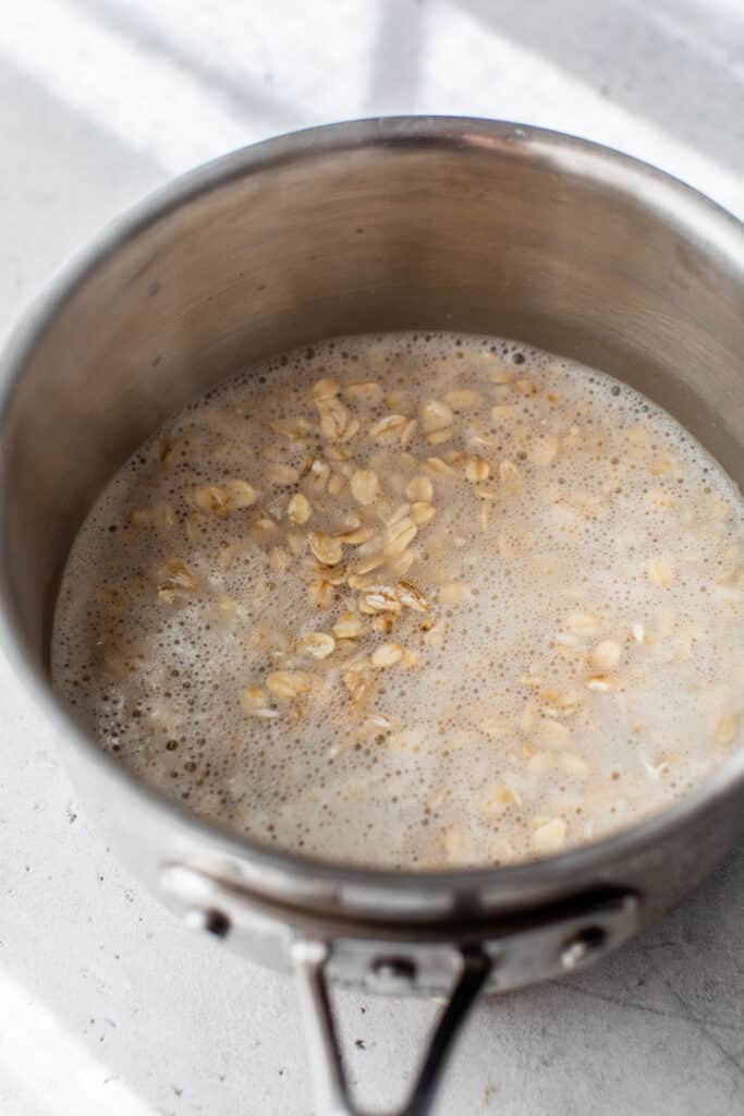 a small saucepan filled with milk, water and oats