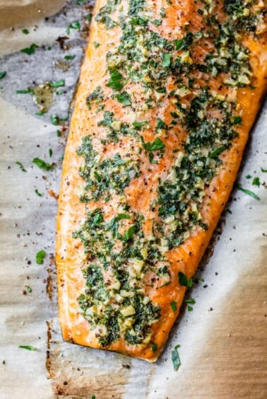 baked salmon fillet with garlic and herbs on parchment paper