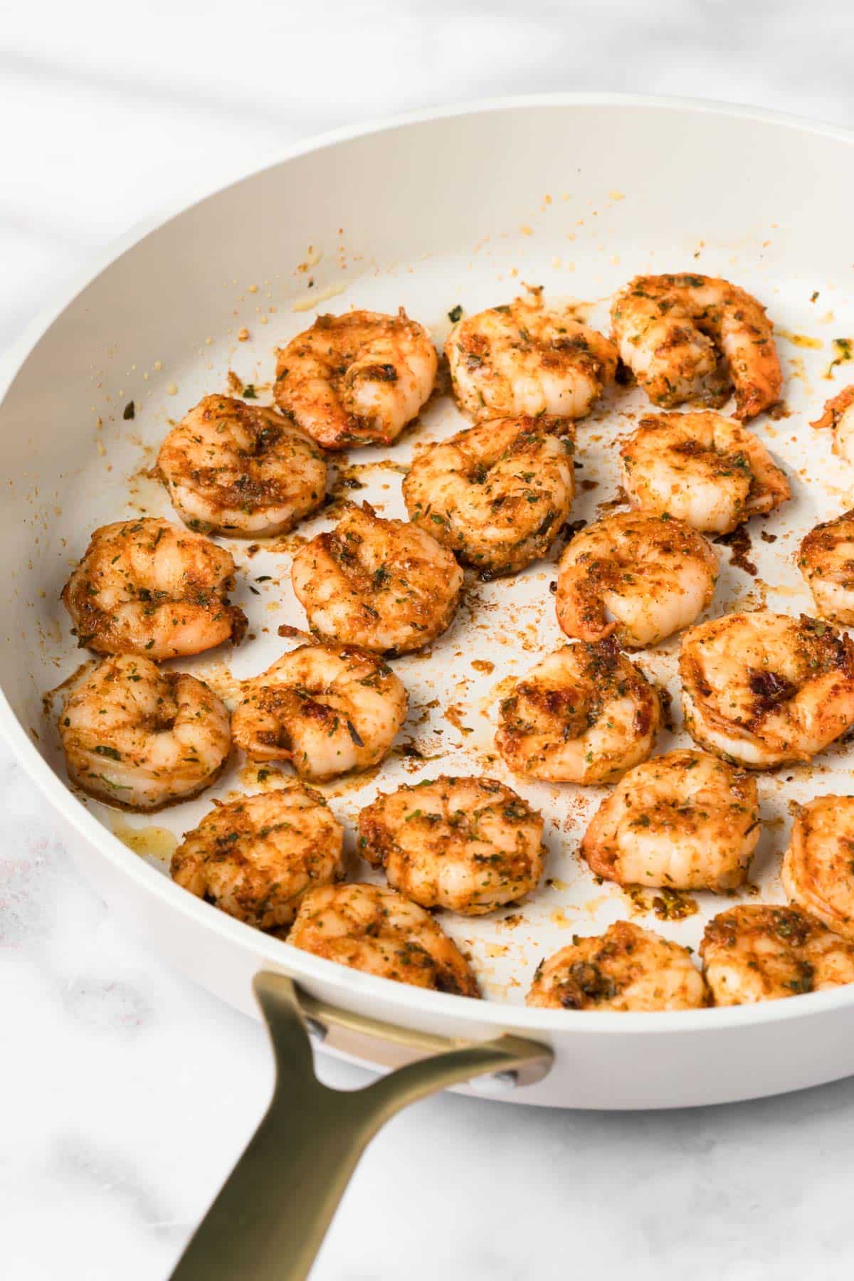 side view of seared shrimp for BBQ shrimp bowls in a skillet.