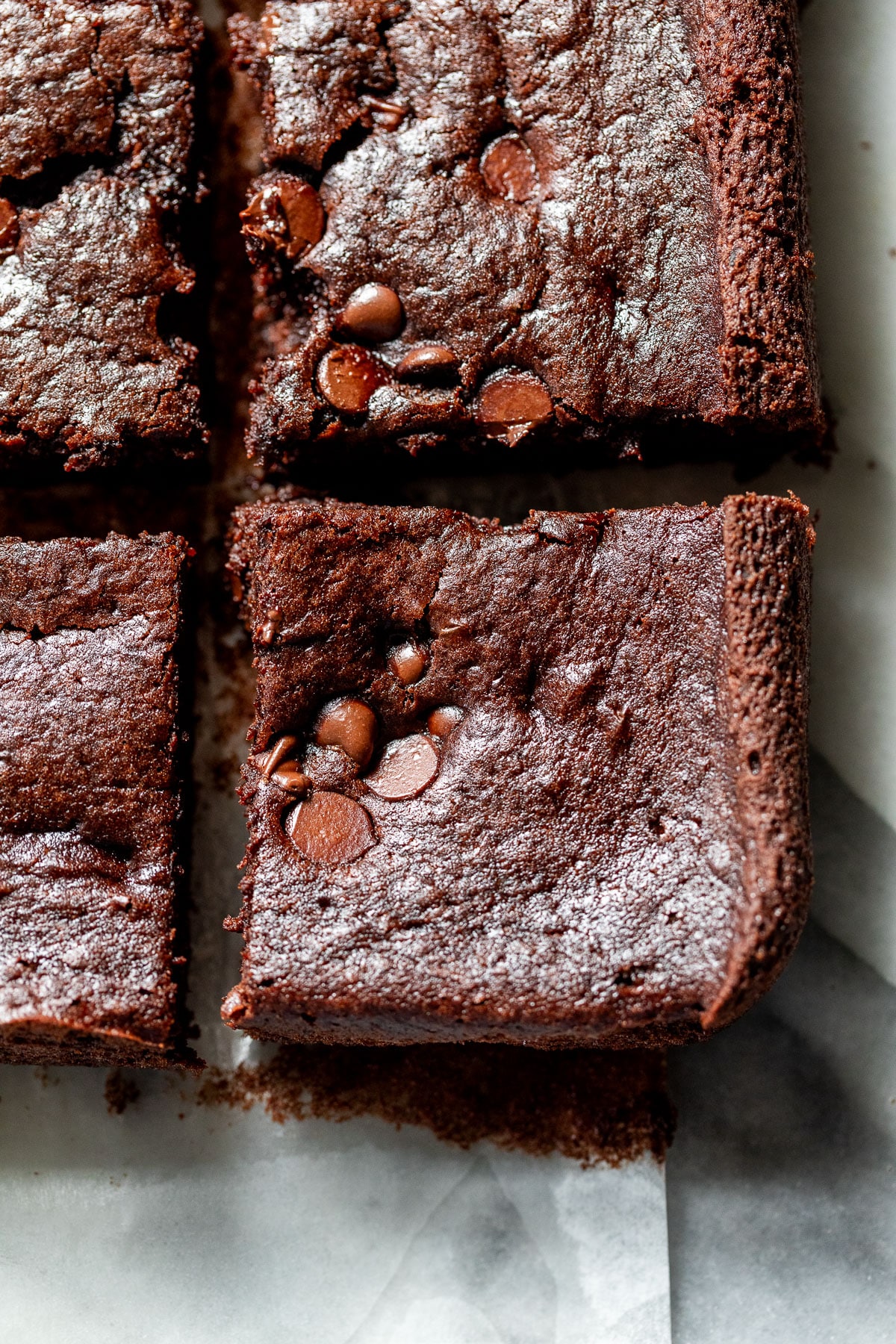 close up on sliced black bean brownies on a piece of parchment paper.