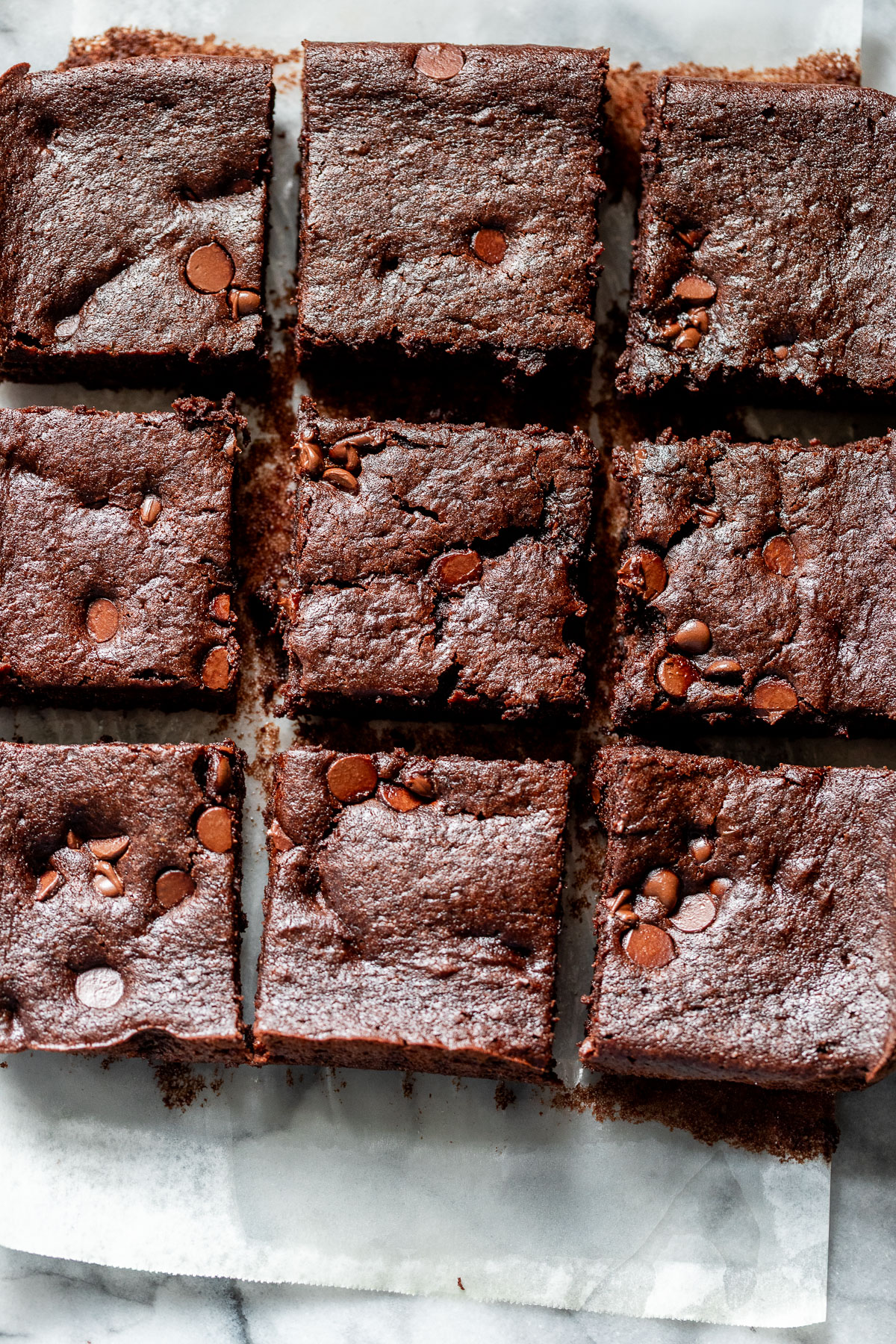 overhead view of sliced black bean brownies on a piece of parchment paper.