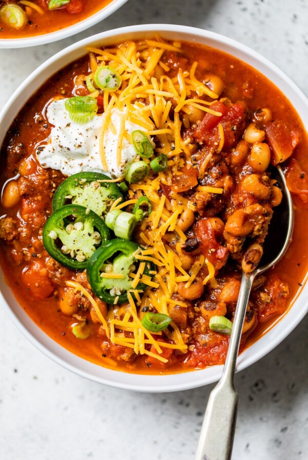 bowl of soup topped with shredded cheese and sour cream