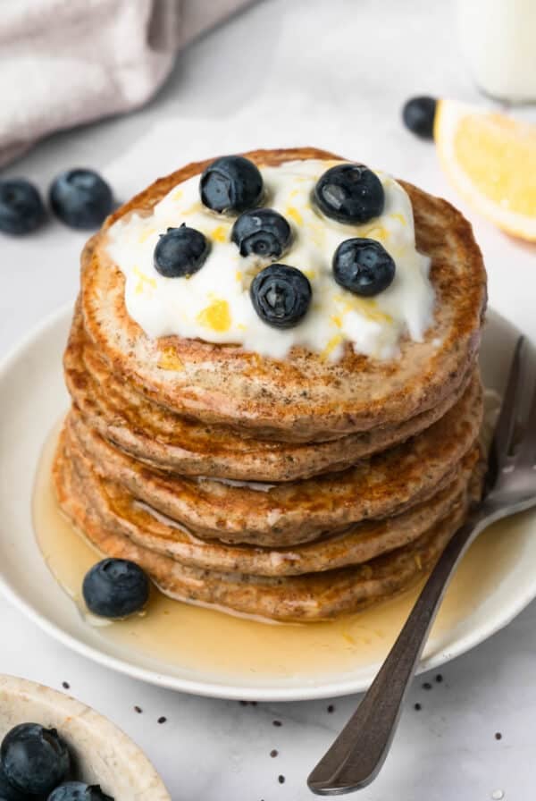 side view of chia seed pancakes topped with lemon yogurt and blueberries.