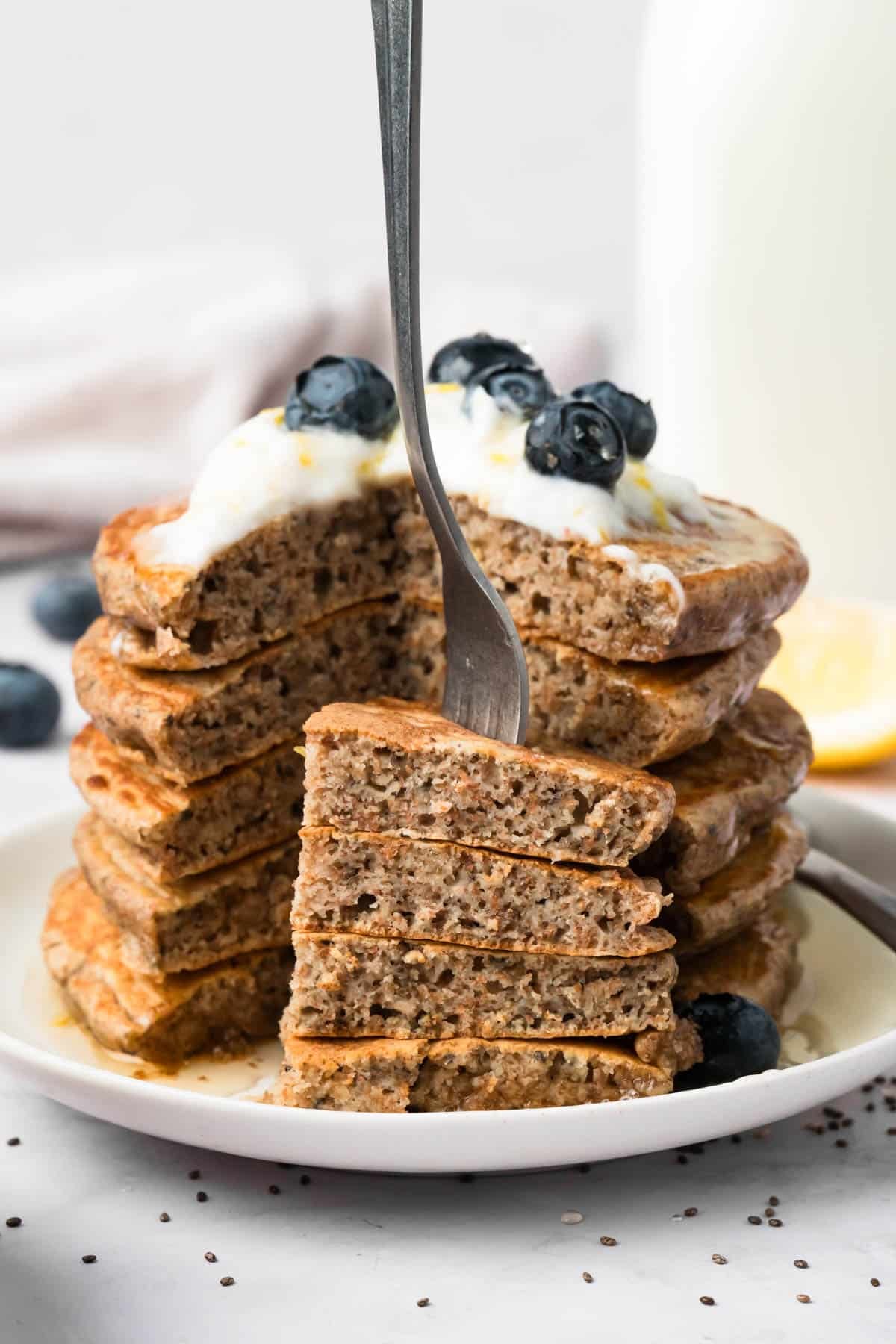 close up on a forkful of chia seed pancakes next to a stack.