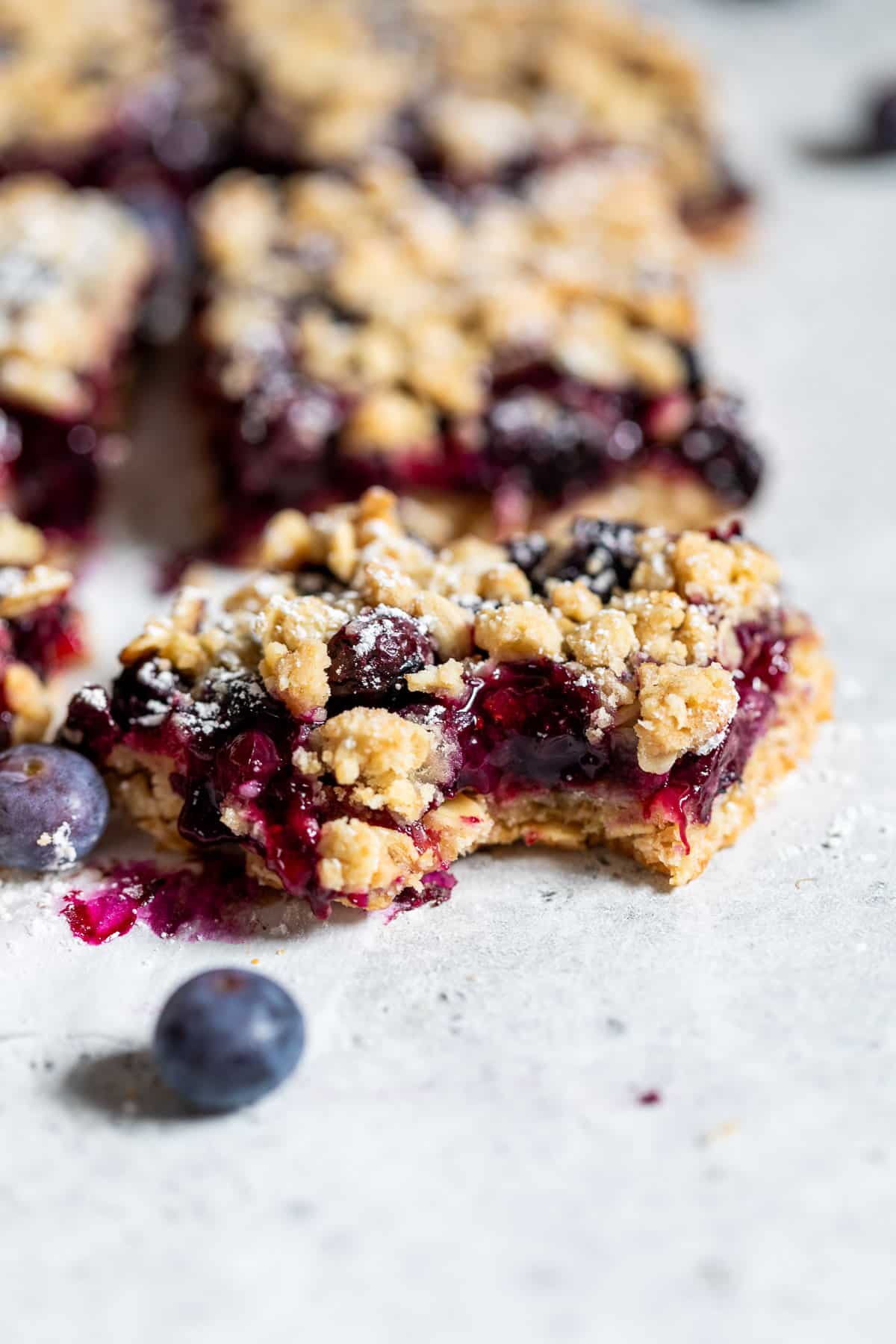 close up on a blueberry pie bar with a bite missing.