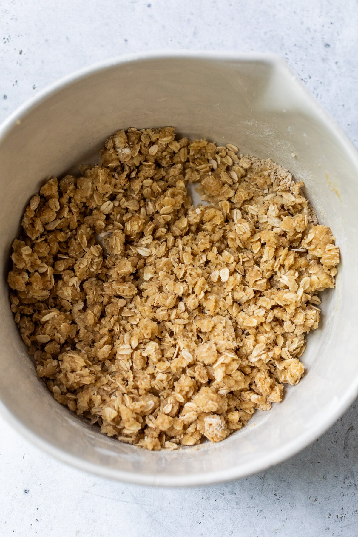 making the crust for blueberry pie bars in a large white bowl.