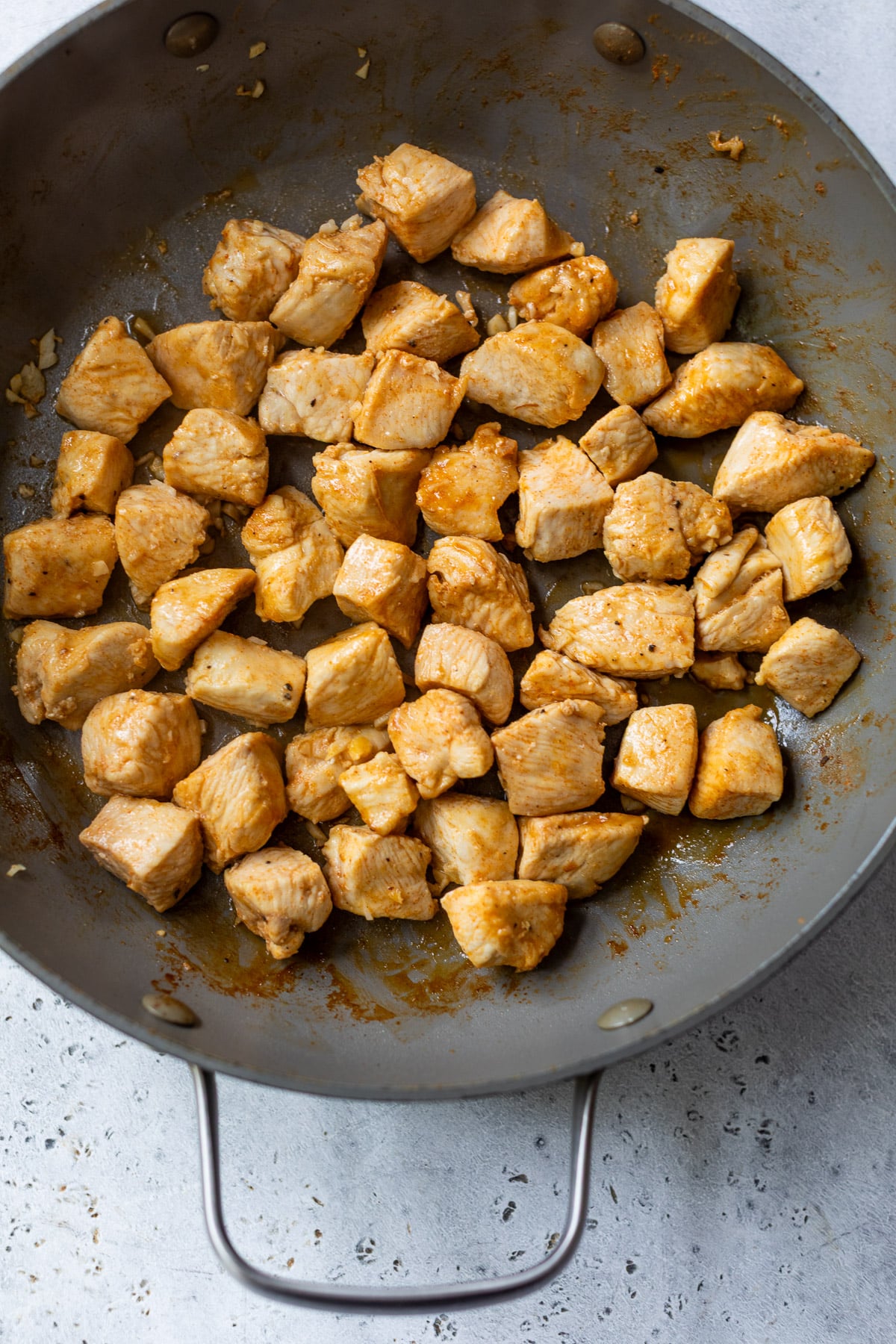 cooking chicken bites in a skillet.