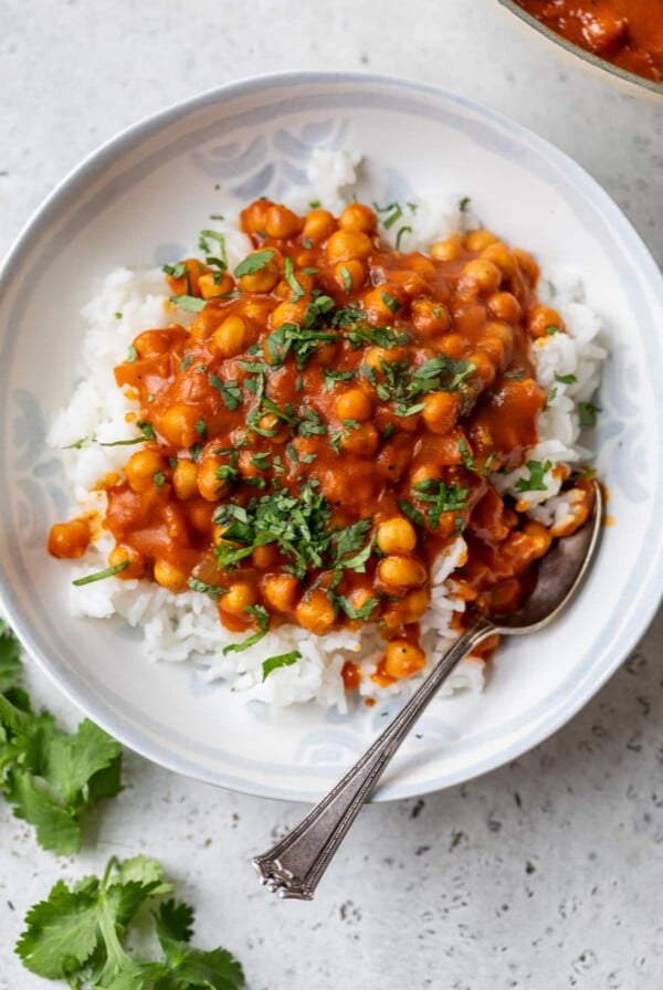 butter chickpeas served over rice in a bowl with a spoon
