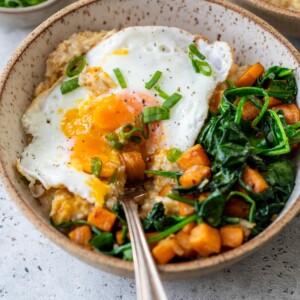 cheesy savory oatmeal in a bowl with a fork
