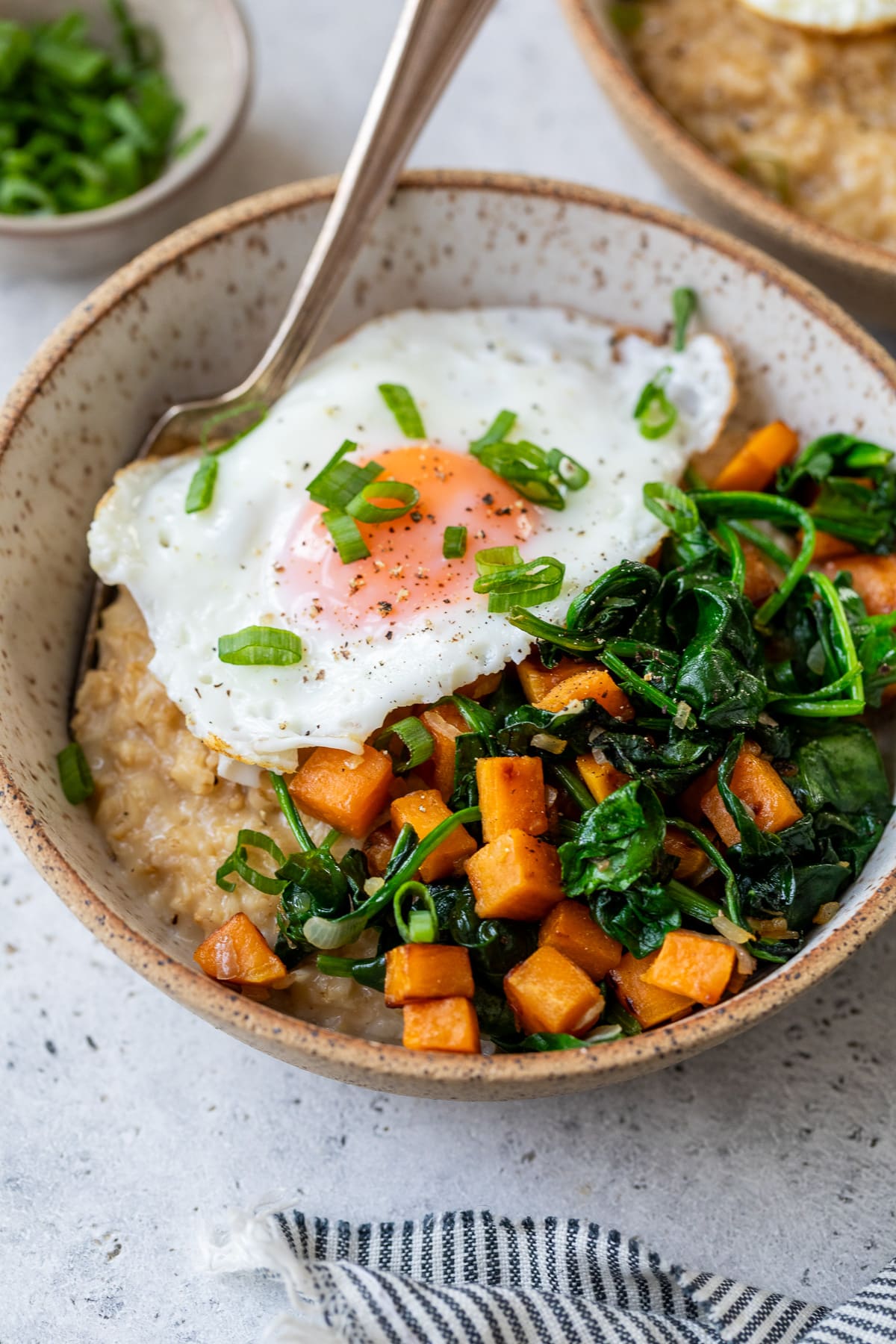 cheesy savory oatmeal in a bowl with a fork