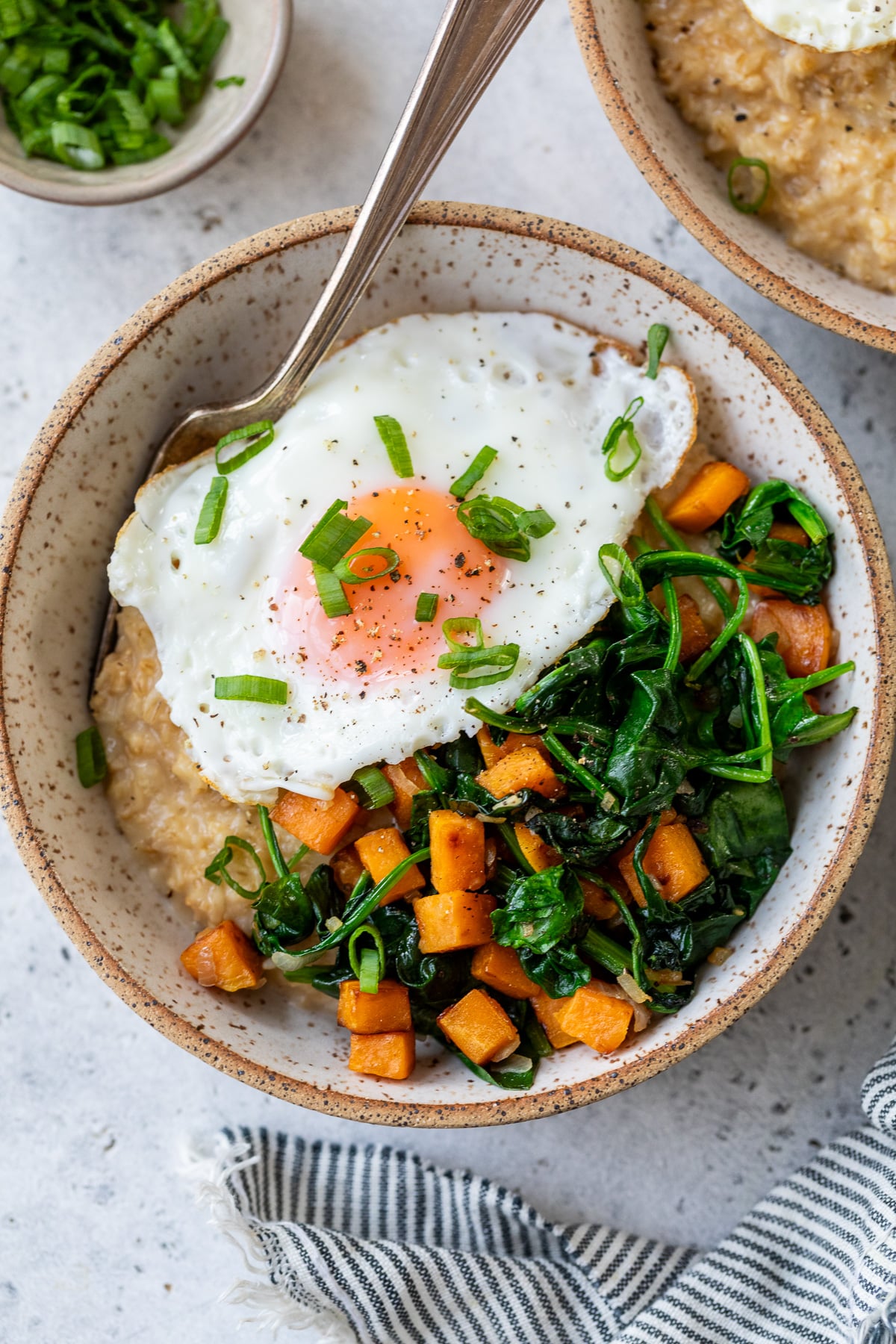 cheesy savory oatmeal in a bowl with a fork