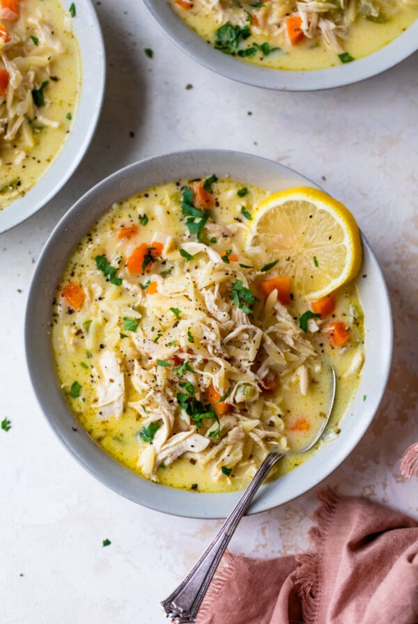 a bowl of the chicken orzo soup and a spoon