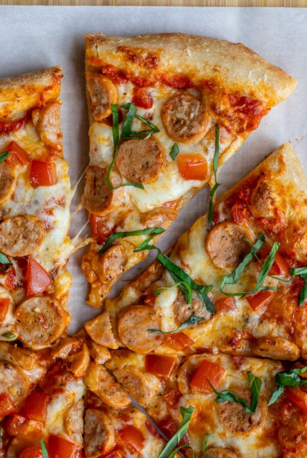 slice of chicken sausage pizza removed from the rest of the pizza