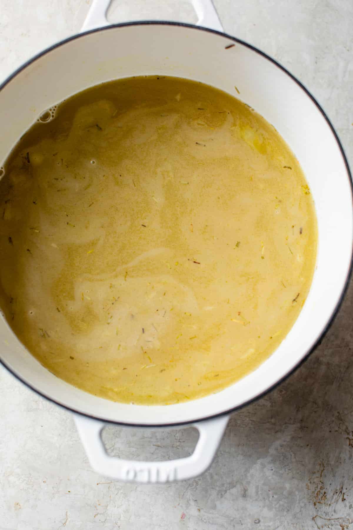 broth and rice added to the vegetables in a dutch oven