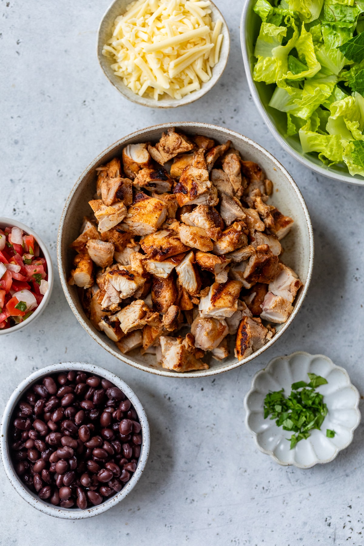 ingredients for Grilled Chipotle Chicken bowls in individual bowls.
