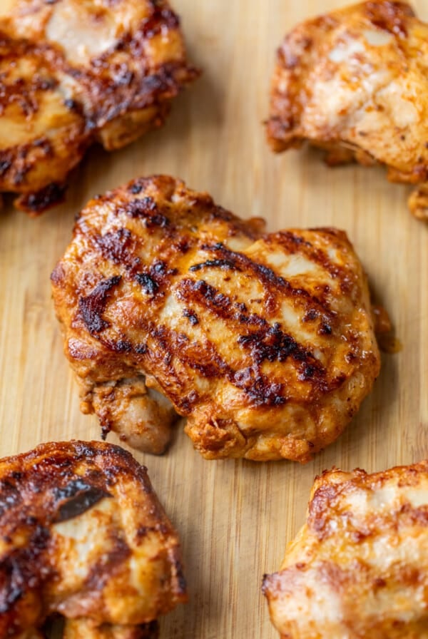 close up on Grilled Chipotle Chicken thighs on a bamboo cutting board.