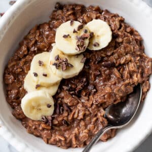 overhead view of a bowl of chocolate oatmeal topped with banana slices.