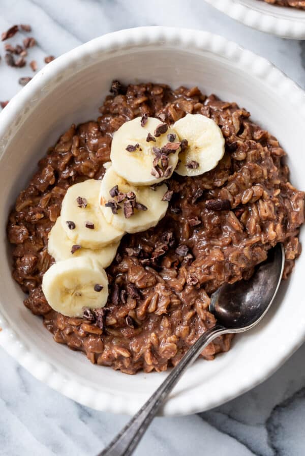 overhead view of a bowl of chocolate oatmeal topped with banana slices.