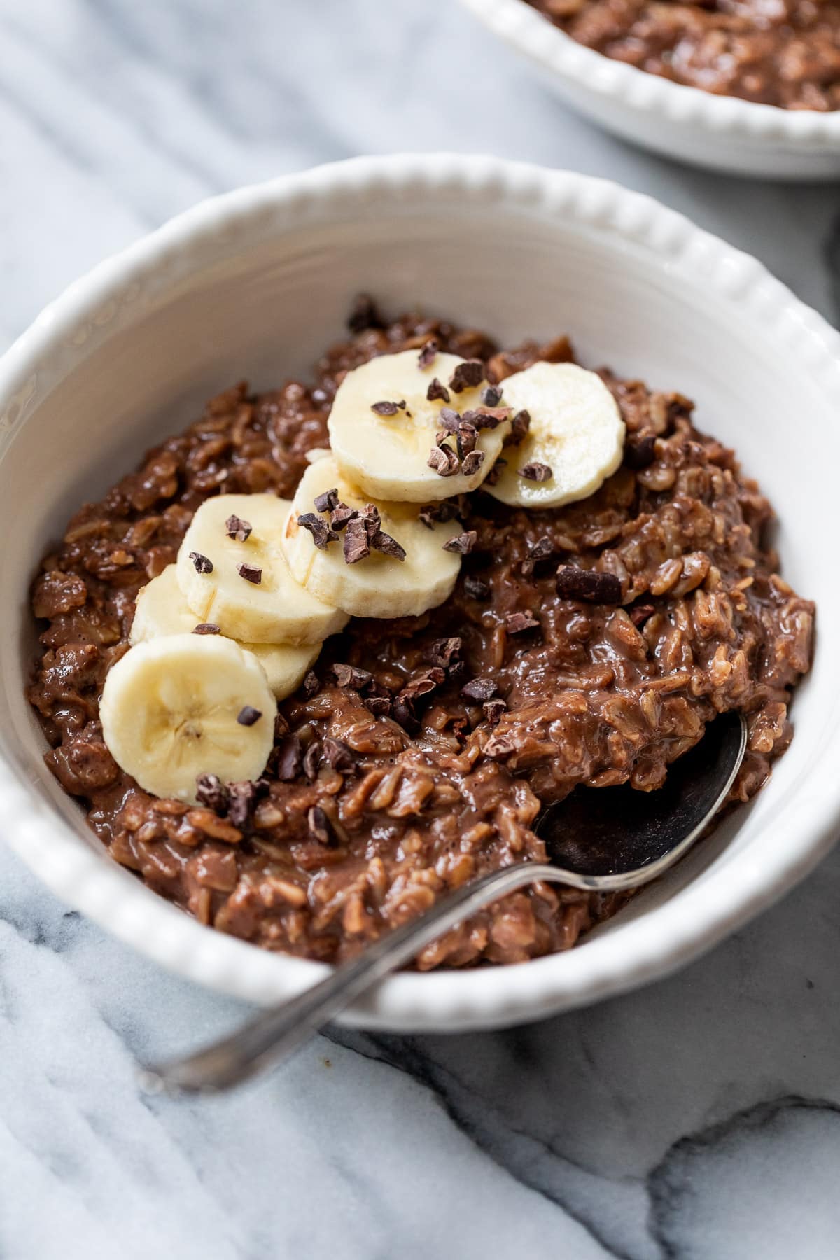 overhead view of a bowl of chocolate oatmeal topped with banana slices.
