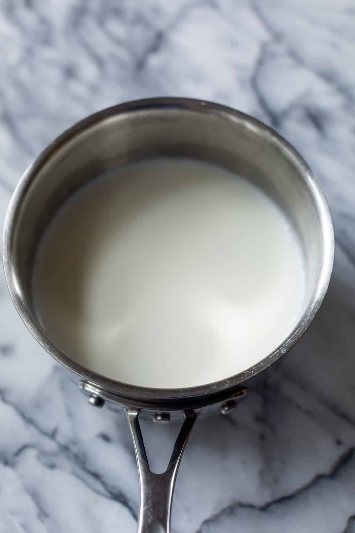 a pot filled halfway with milk.