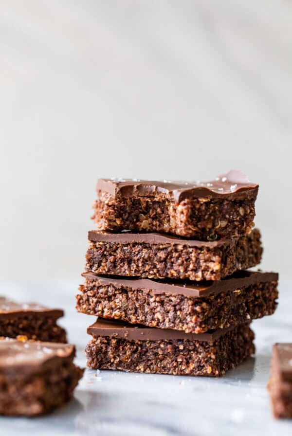 a stack of 4 chocolate bars on a table with a bite taken out of the top one