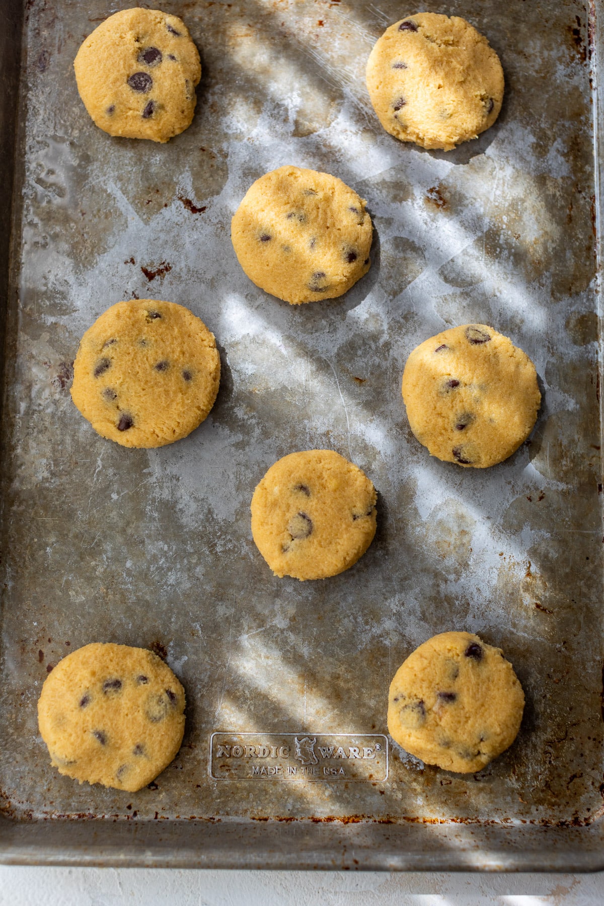 unbaked coconut flour cookies on a metal baking sheet.