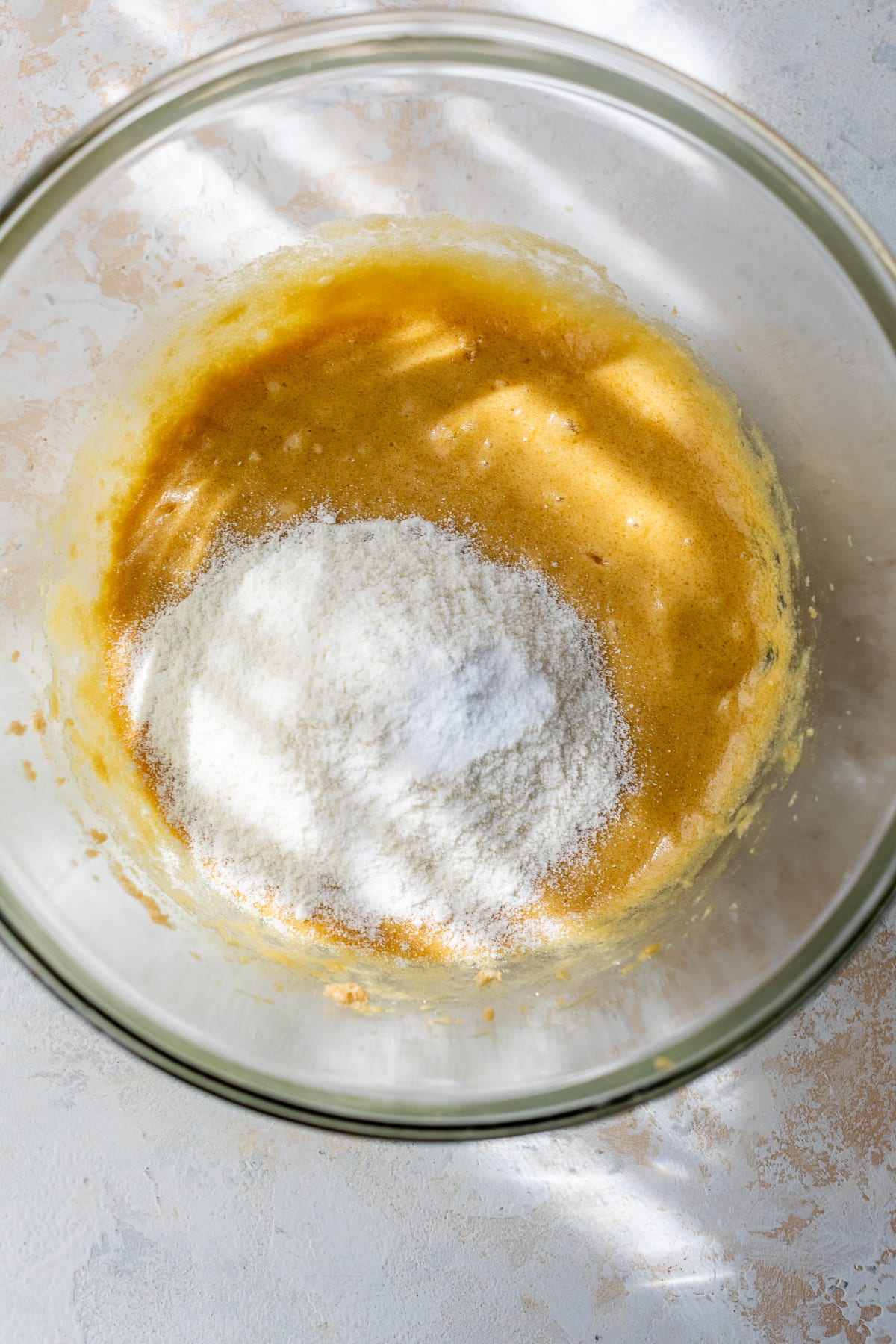 dry ingredients on top of wet coconut flour cookie batter in a large glass bowl.