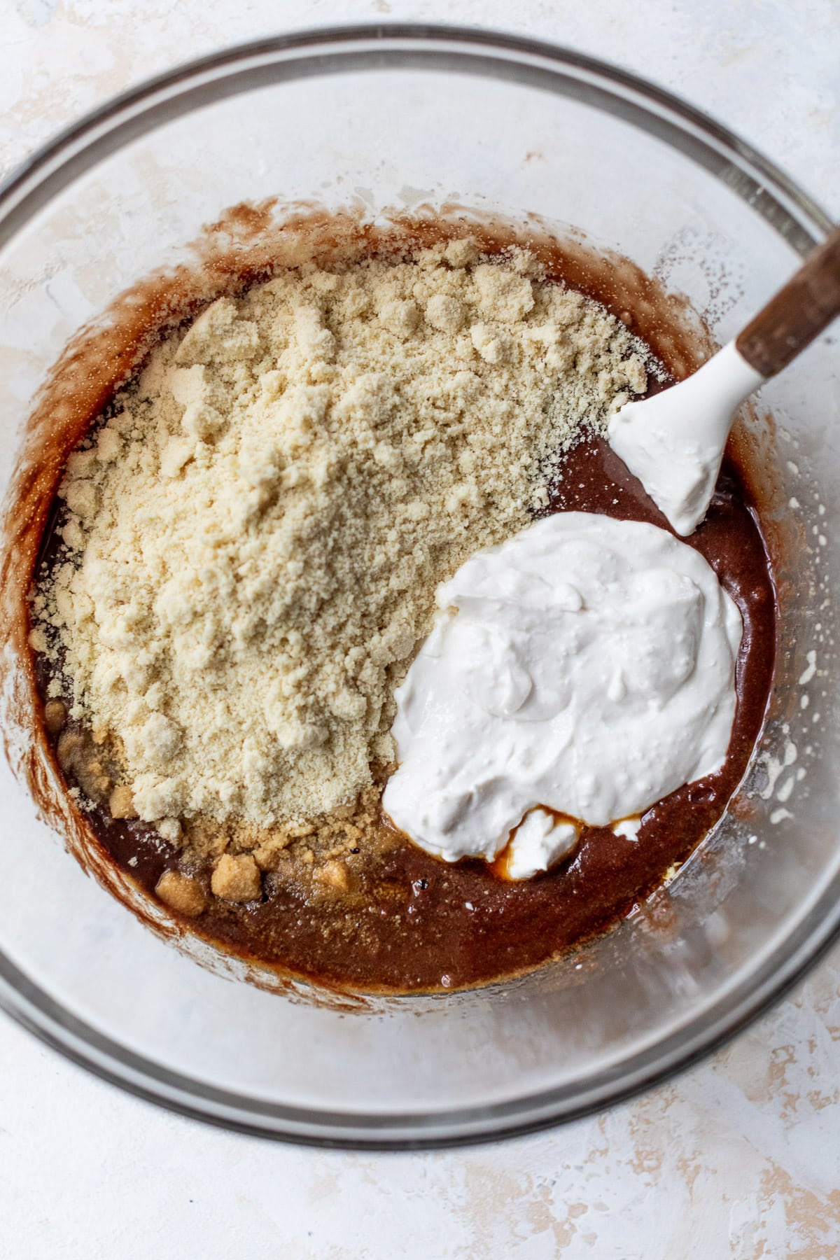 overhead view of the ingredients for cottage cheese brownies in a large glass bowl.