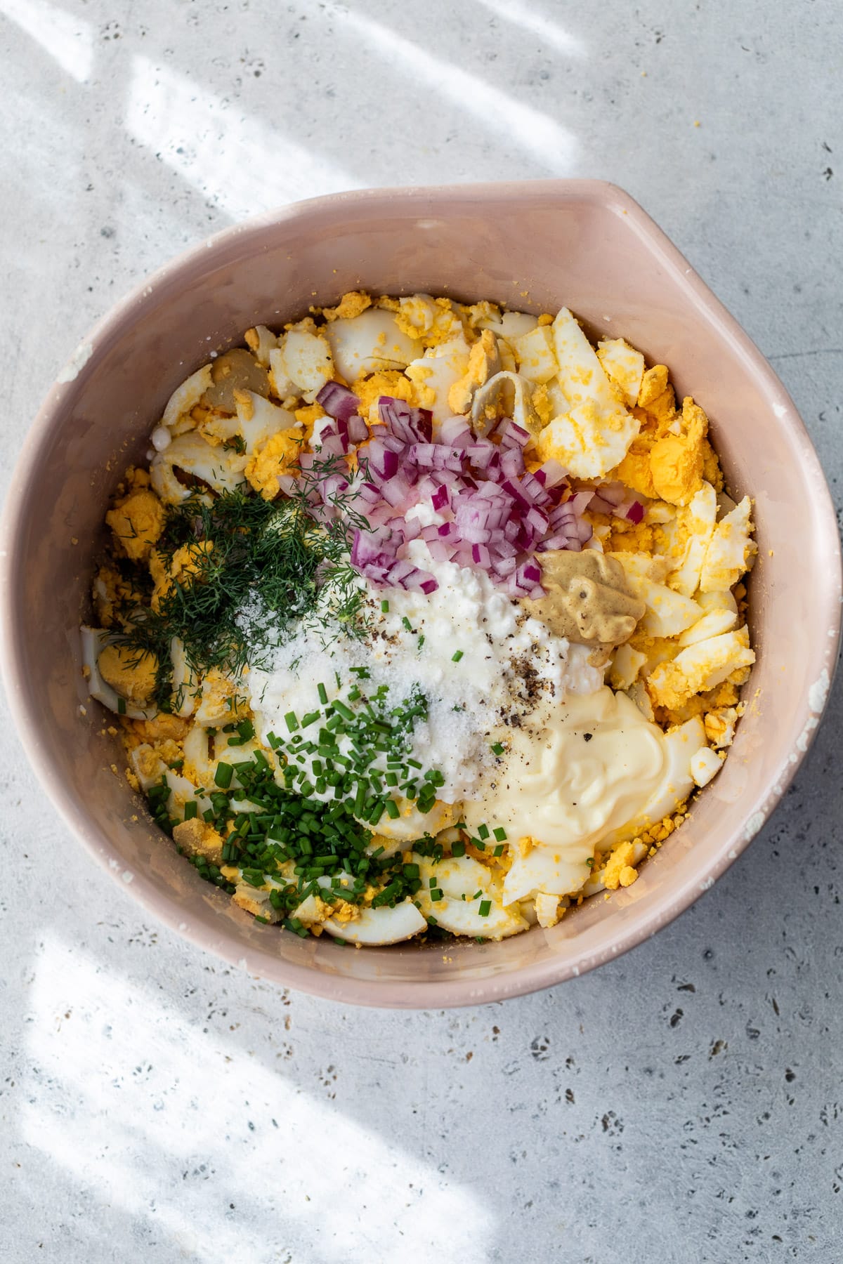 the ingredients for Cottage Cheese Egg Salad in a large pink bowl.