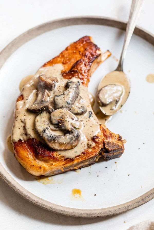 bone-in porch chop on a plate with mushroom sauce