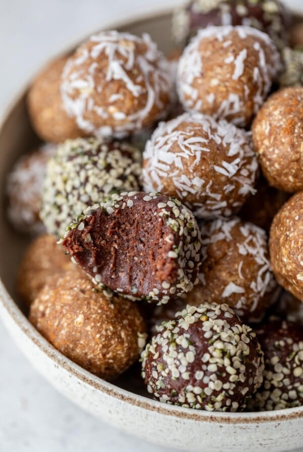 date energy balls in a bowl with a bite taken out of one