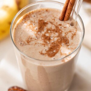 date smoothie in a glass with a straw and cinnamon stick