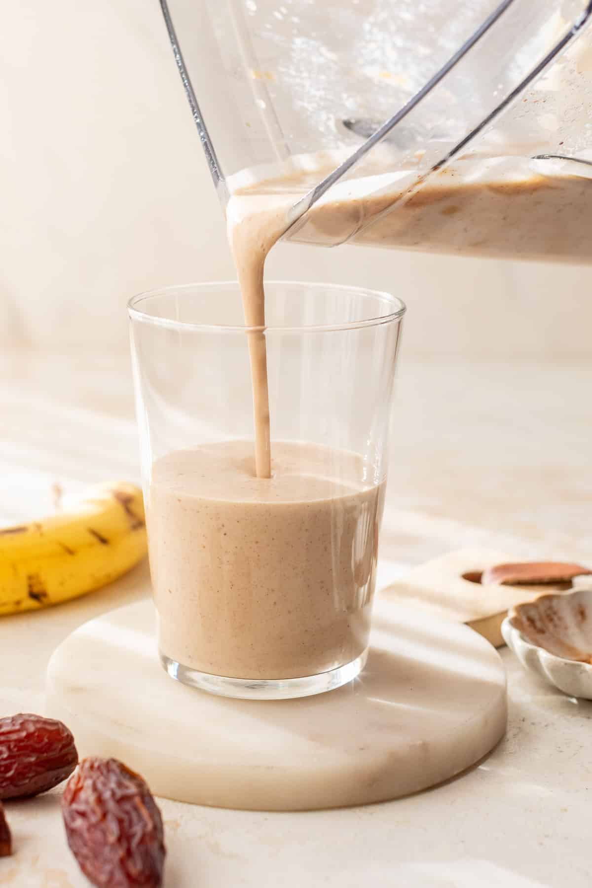 date smoothie being poured into a glass