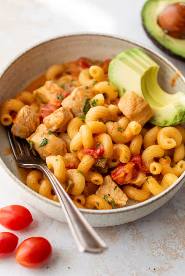 overhead view of a bowl of Chicken Fajita Pasta topped with sliced avocado.