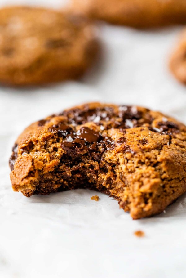 close-up side view of a flourless chocolate chip cookie with a bite taken out