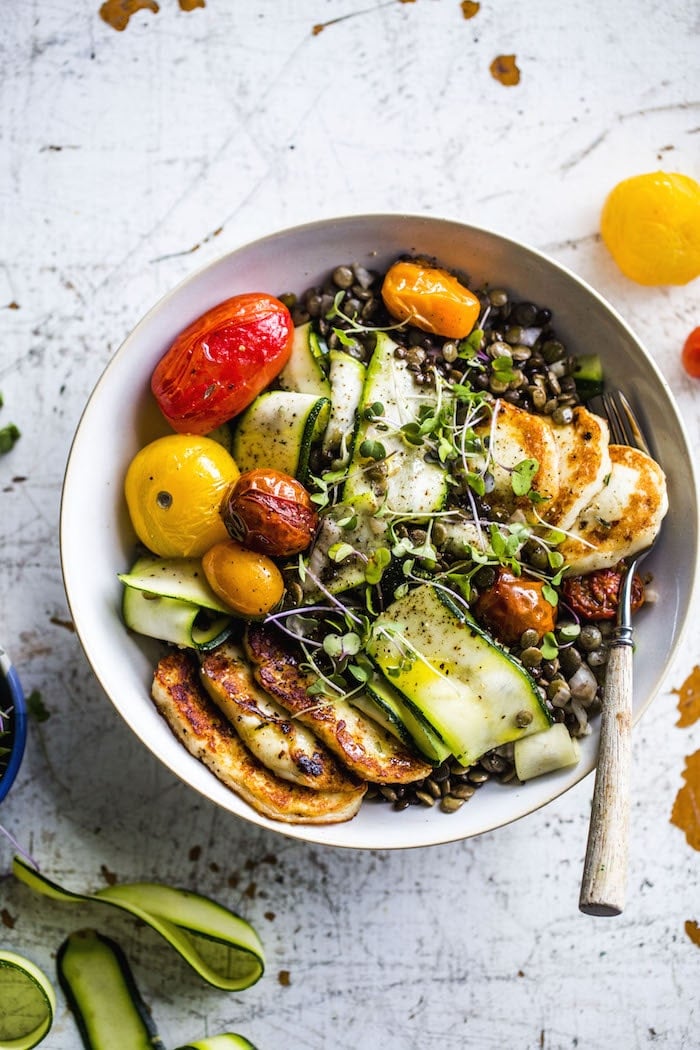 A fresh lentil salad topped with fried halloumi, roasted tomatoes and zucchini | thealmondeater.com
