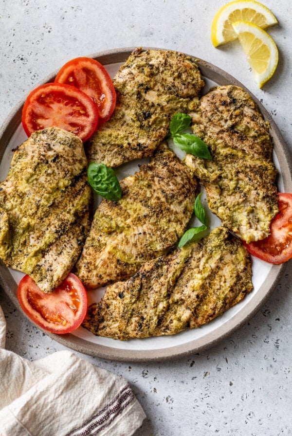 grilled pesto chicken breasts on a plate.