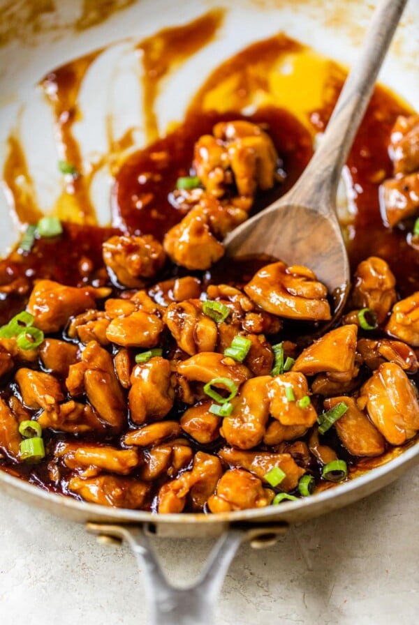 diced cooked chicken in a skillet with an Asian sauce and green onions