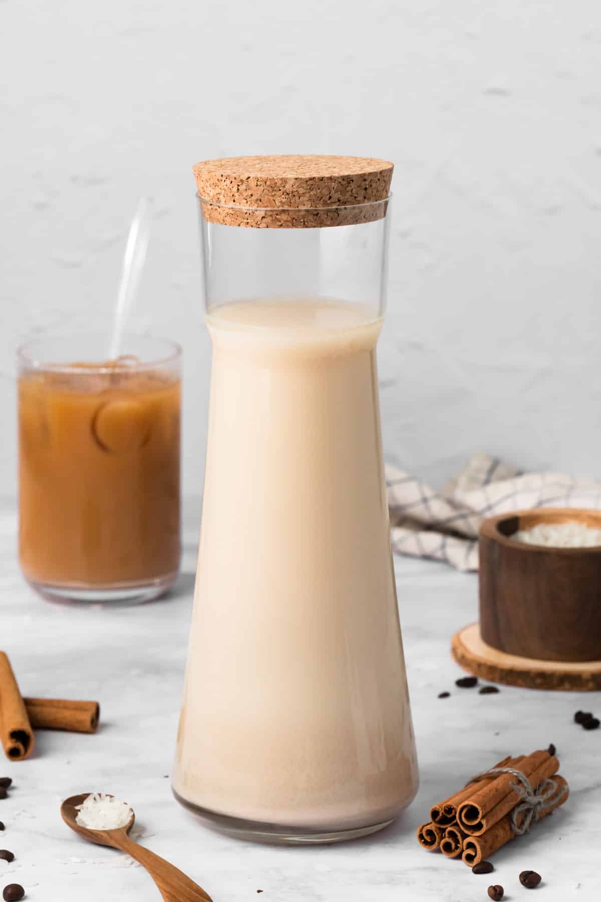 side view of horchata in a pitcher with a horchata latte in the background.