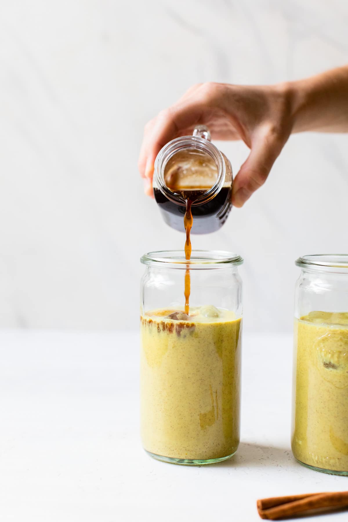 someone pouring espresso into a glass