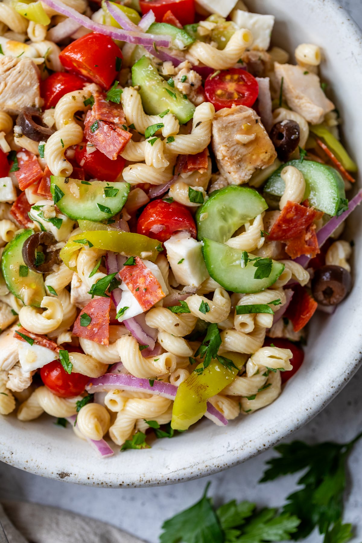 close up on Italian pasta salad in a large white bowl.